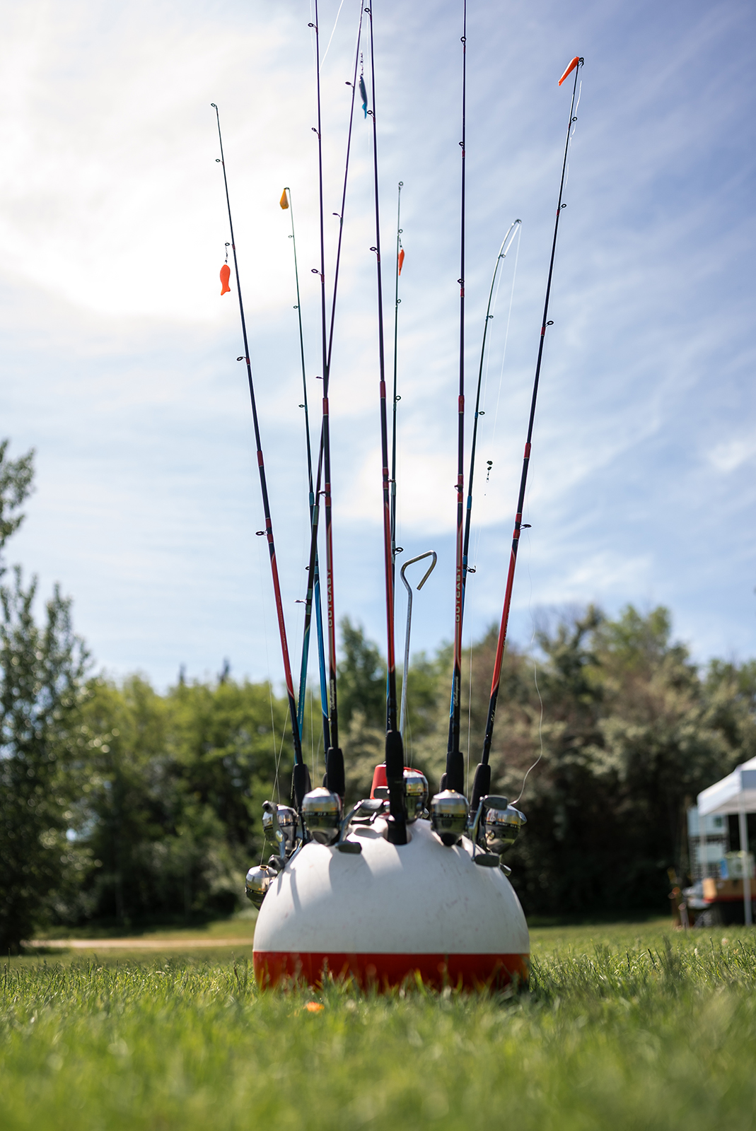 እንደ ትልቅ ቦበር ቅርጽ ካለው መያዣ ላይ የሚጣበቁ የበርካታ የዓሣ ማጥመጃ ዘንግዎች ፎቶ።